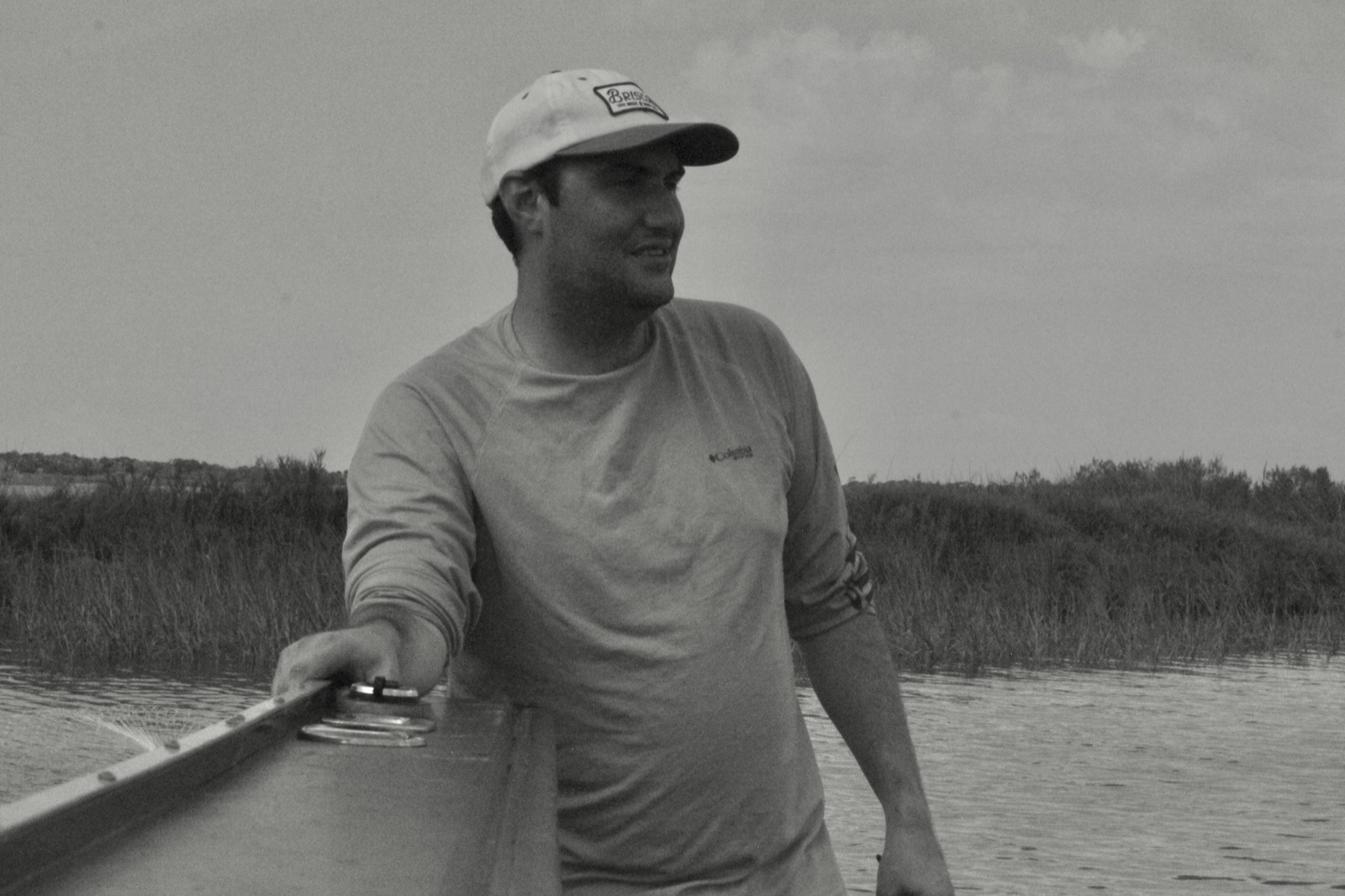 Angler steadying a skiff in the marsh